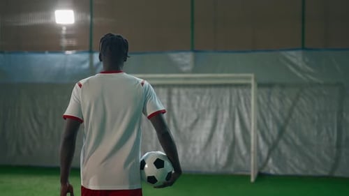 Soccer Player Stands with Ball near Goal