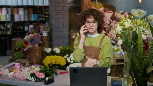 Florist Speaking on Phone with Customer during Workday in Flower Store
