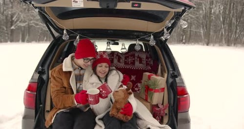 Family Sitting in a Car Among Winter Forest