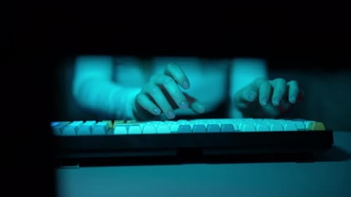 Typing on Multicolored Keyboard at Night