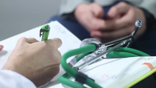 Doctor Taking Notes During Patient Visit