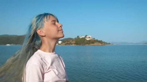 Happy Girl with Blue Hair on the Background of the Sea