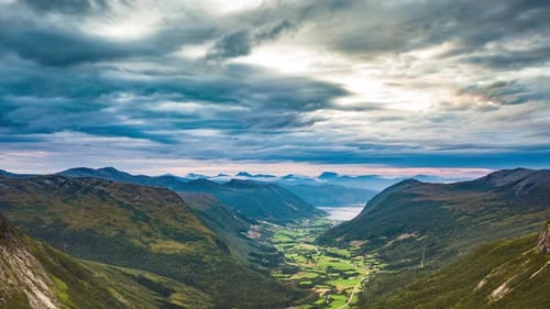Dunkle Sturmwolken ziehen über das enge Tal. Berge ragen an seinen Seiten empor. Blaues Wasser von
