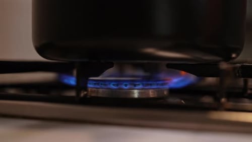 Closeup of Turning on Gas Stove Black Pot Heating on Gas Stove with Blue Flame Perfect for Cooking