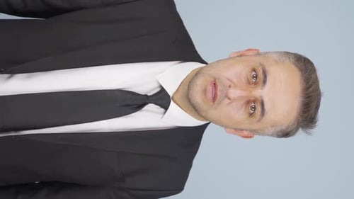 Adult in Suit Speaks Directly to Camera