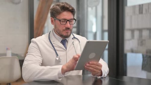 Young Doctor Using Digital Tablet in Clinic