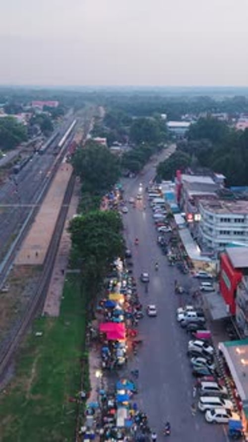 Street Market Next to the Train Tracks in a Small Village Showing Vendors and Traffic