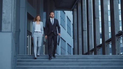 Business Professionals Walking Down Stairs in a Modern Office Showcasing Teamwork