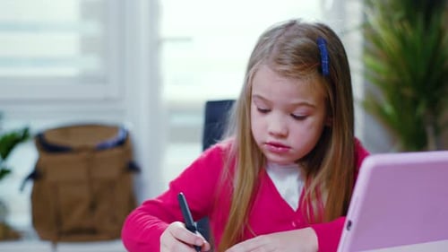 Child Focused on Drawing and Writing at Desk
