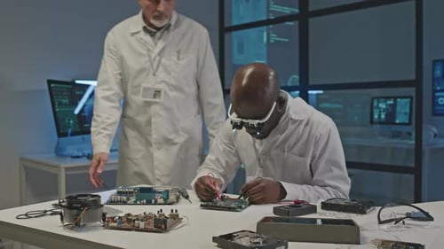Electronics Scientists Repairing Circuit Board in Laboratory