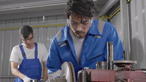 Young man sanding or iron at industrial factory, mechanic working job while polish metal.