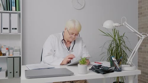 Woman doctor using tablet during working day at clinic.