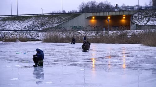 Ice fishing. fisherman fishing on a winter lake against a background of forest and blue sky.