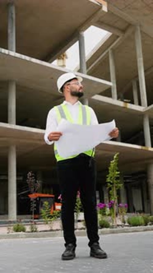 Arquitecto profesional que examina los planos de construcción en el sitio
