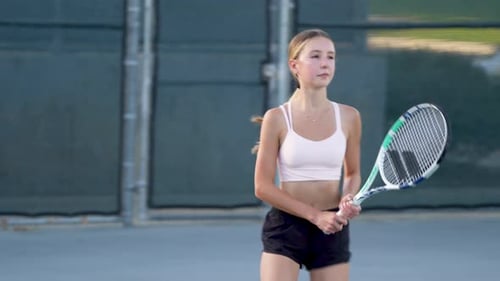 Young Girl Playing Tennis on Outdoor Court