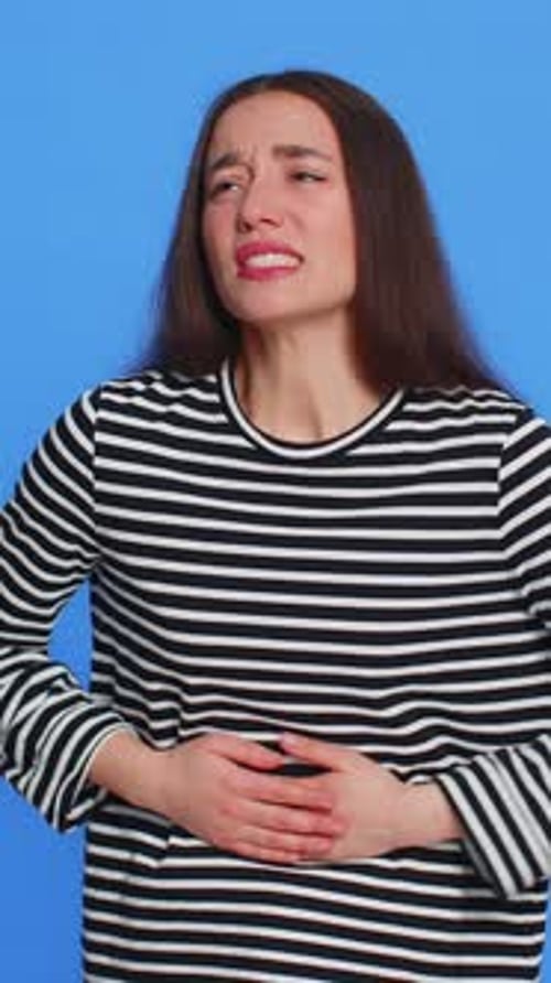 Mujer caucásica enferma que sufre de calambres menstruales, dolor de estómago, dolor abdominal, dolor menstrual, diarrea