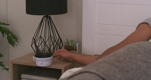 Man Waking Up and Turns Off Alarm Clock