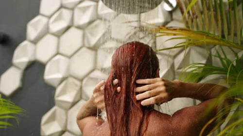 Woman Washing Long Red Hair in Tropical Shower