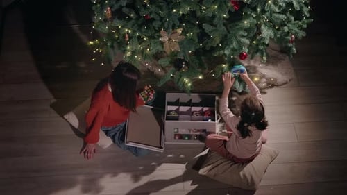 Woman and Girl Decorating Christmas Tree from Above