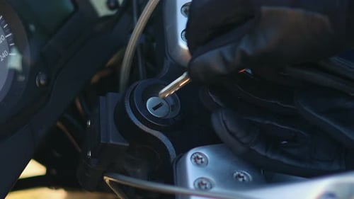 Biker with gloves inserting the key into the motorcycle ignition