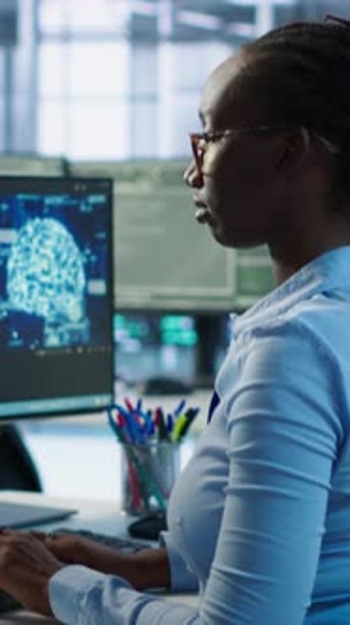 Woman Typing at Computer with Colleague Helping