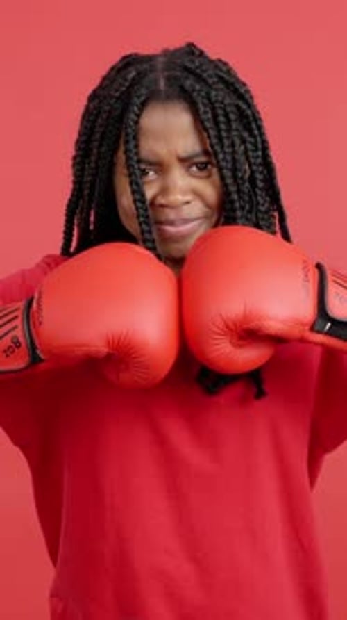 Woman with Boxing Gloves on Red Background Punches