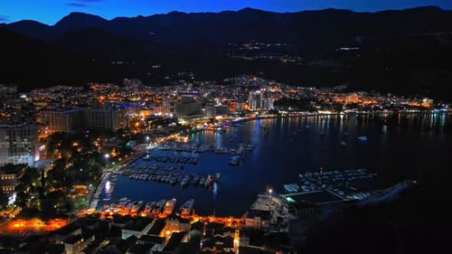 Night City with Electric Lights Against the Backdrop of Slopes of the Montenegrin Mountains and the
