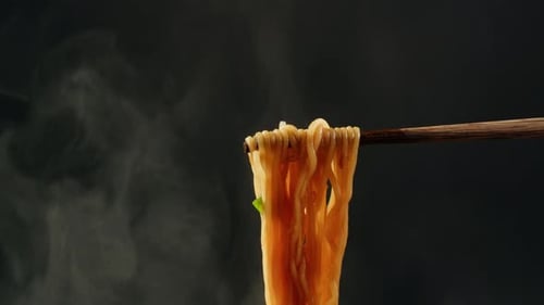 Steaming Noodles Held by Chopsticks in Close-Up
