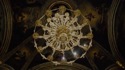 Tracking shot of a golden big chandelier inside a big cathedral