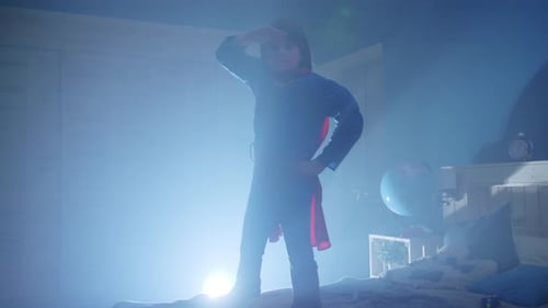 Boy in Costume Standing on Bed in Bedroom