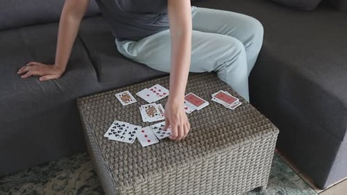 Woman Lays Out Playing Cards on a Table in a Living Room