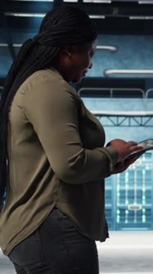 Vertical Video Smiling Data Center Technician Using Tablet to Manage Software Updates