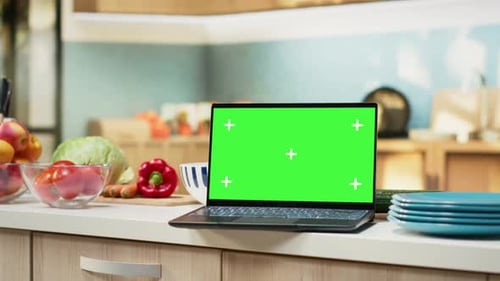 Green Screen on Laptop in Modern Home Kitchen with Cupboards and Cookware