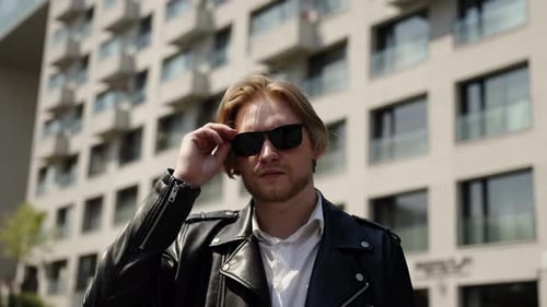 Fashionable Man in Black Glasses in Sunny Summer Light and Buildings in the Background Summer Mood