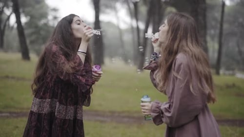 Best girlfriends celebrating friendship blowing bubbles in slow motion