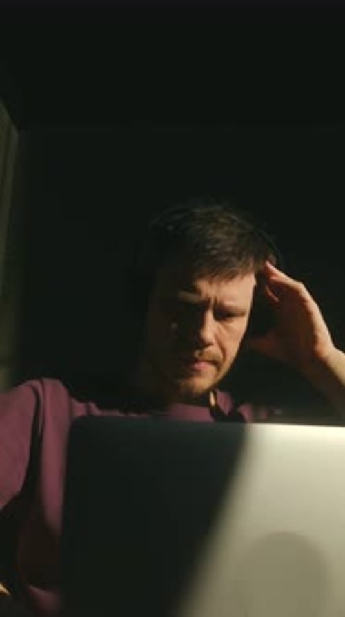 Engagierte Person, die Programmierprobleme bei gedämpftem Licht bewältigt