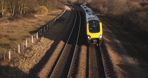 Un pequeño tren de pasajeros que pasa por debajo de un puente peatonal