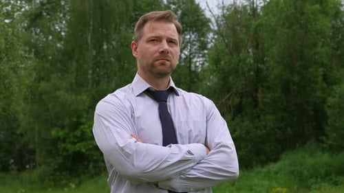 Confident Businessman in Natural Setting Man Stands in Front of Lush Green Backdrop Remote Working