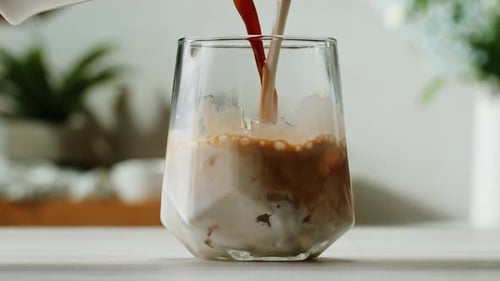 Pouring Coffee and Milk into Iced Glass