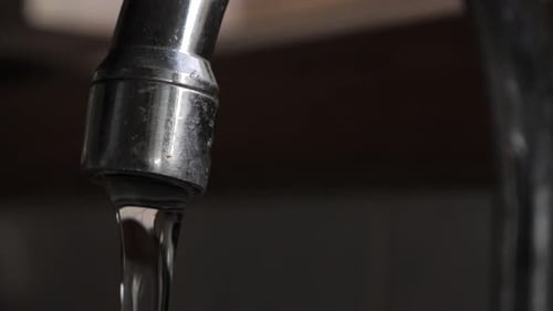 Close Up of Water Running From Silver Faucet