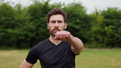 Man Stretching Arms Before Workout in Park