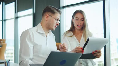 Colleagues Discussing Project Details in Modern Office During Daytime with City View and Arguing