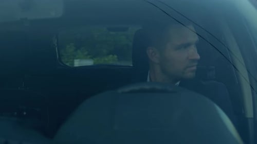 Man Drives Car in Urban Setting