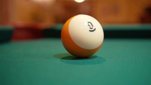 Slow Motion Billiards yellow striped 9 ball shot in corner pocket on pool table with green felt and