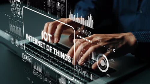 Mãos digitando no teclado cercado por gráficos digitais que representam a tecnologia da Internet das Coisas e