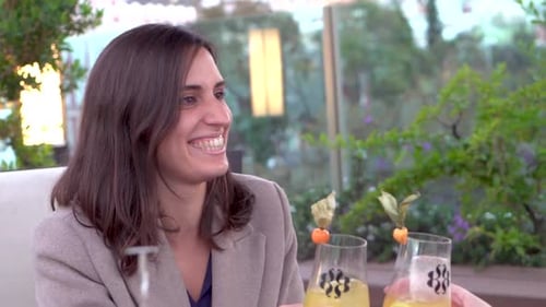 Stylish Woman Toasting with a Friend at Restaurant