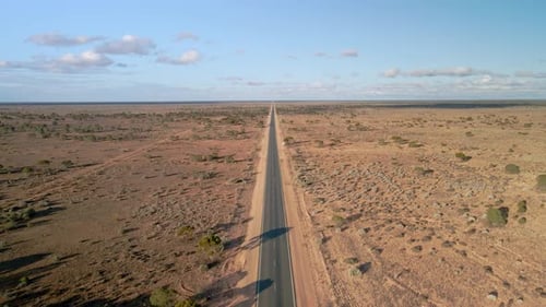 Aerial view above 90 miles straight road, australia on a sunny, desert outback, landing, drone shot