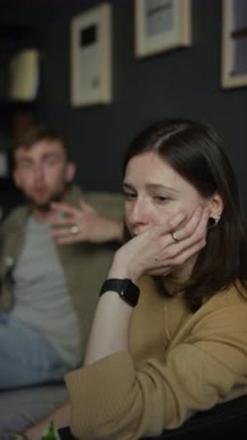 Upset Woman Listening to Arguing Man on Couch