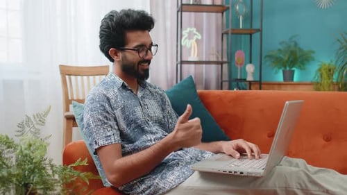 Man on Couch Making Video Call on Laptop
