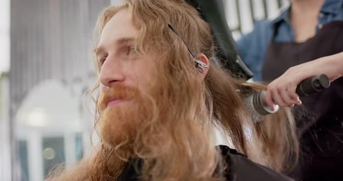 Hairdresser Styling Long Hair with Brush and Dryer
